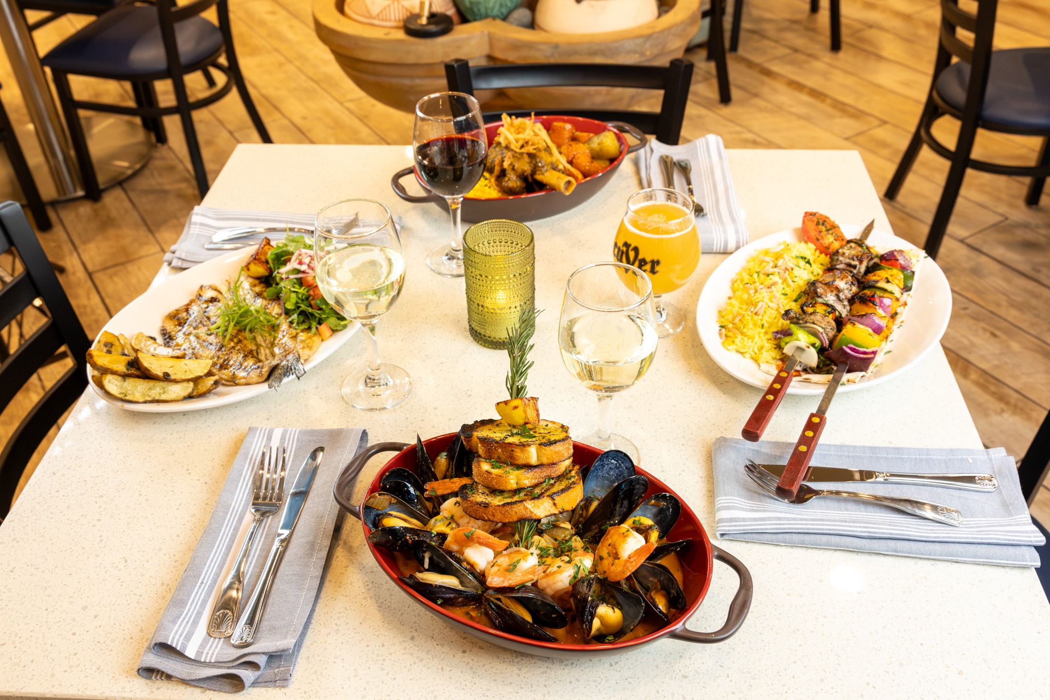 Full table spread with entrées, wine, and beer