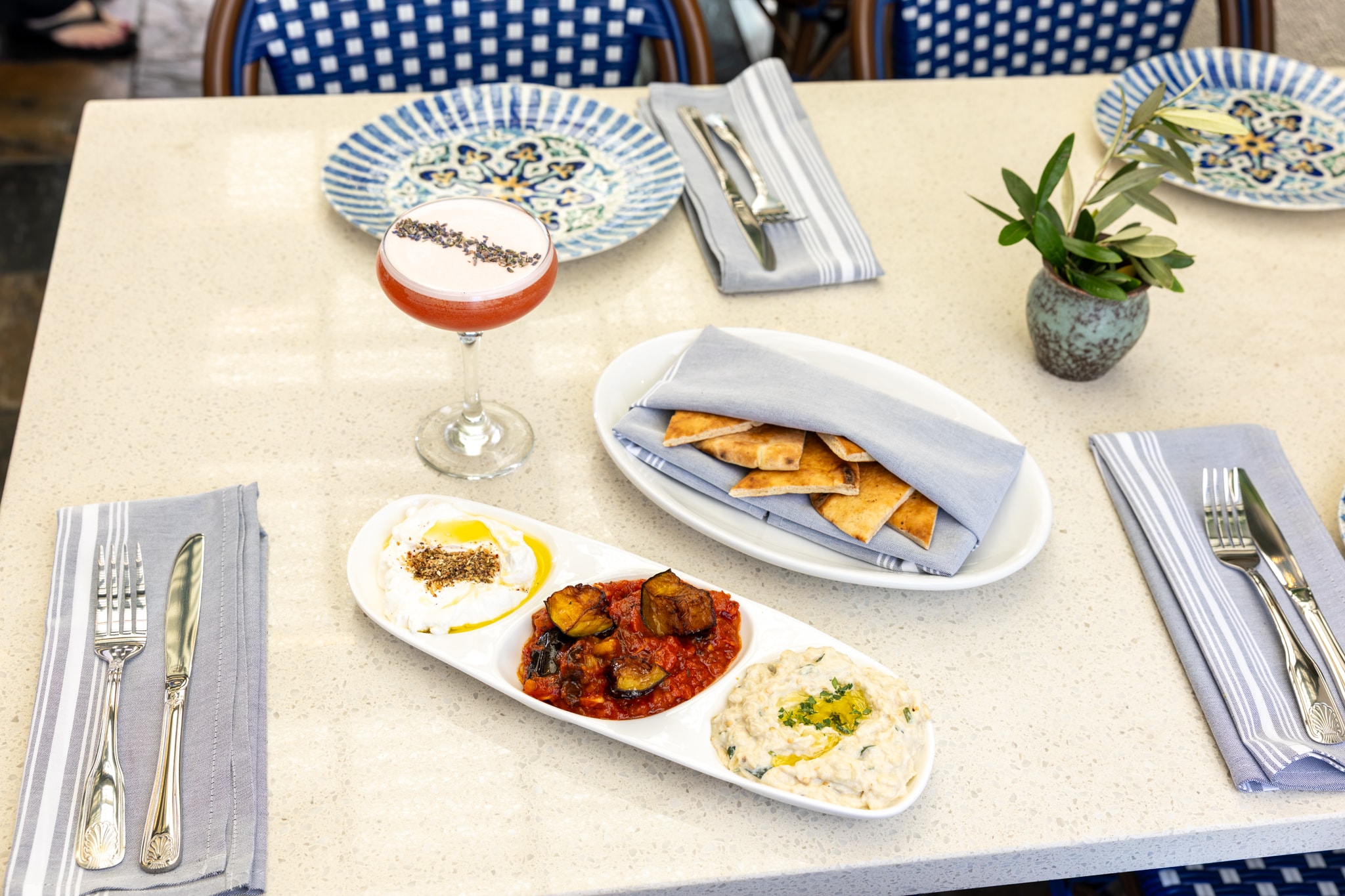 Maza trio with cocktail and pita on the patio
