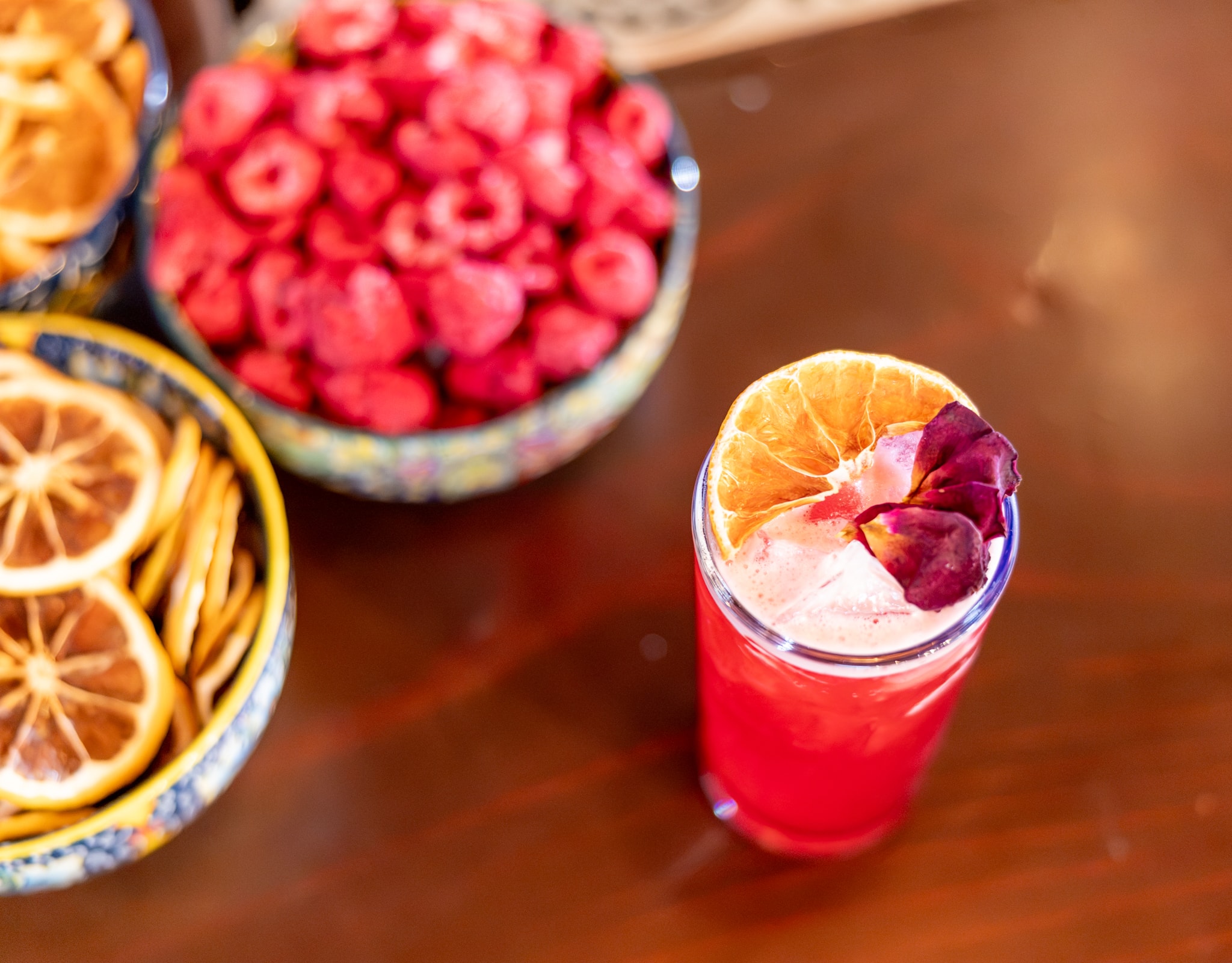Raspberry rose cocktail with dried citrus garnish and fresh raspberries